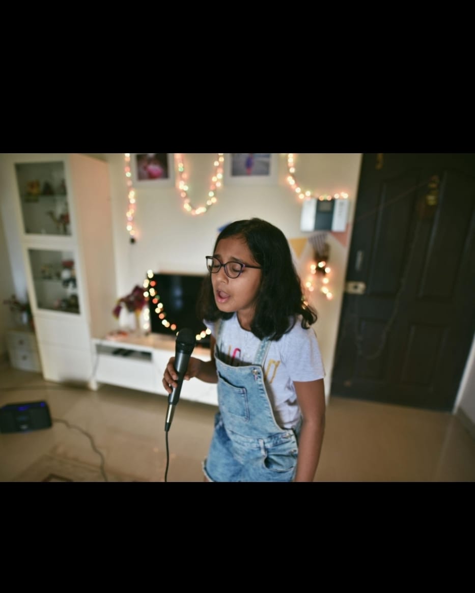 Child singing into a microphone at home